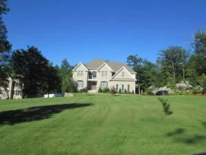 Residential property inspected — large suburban house manicured lawn 4